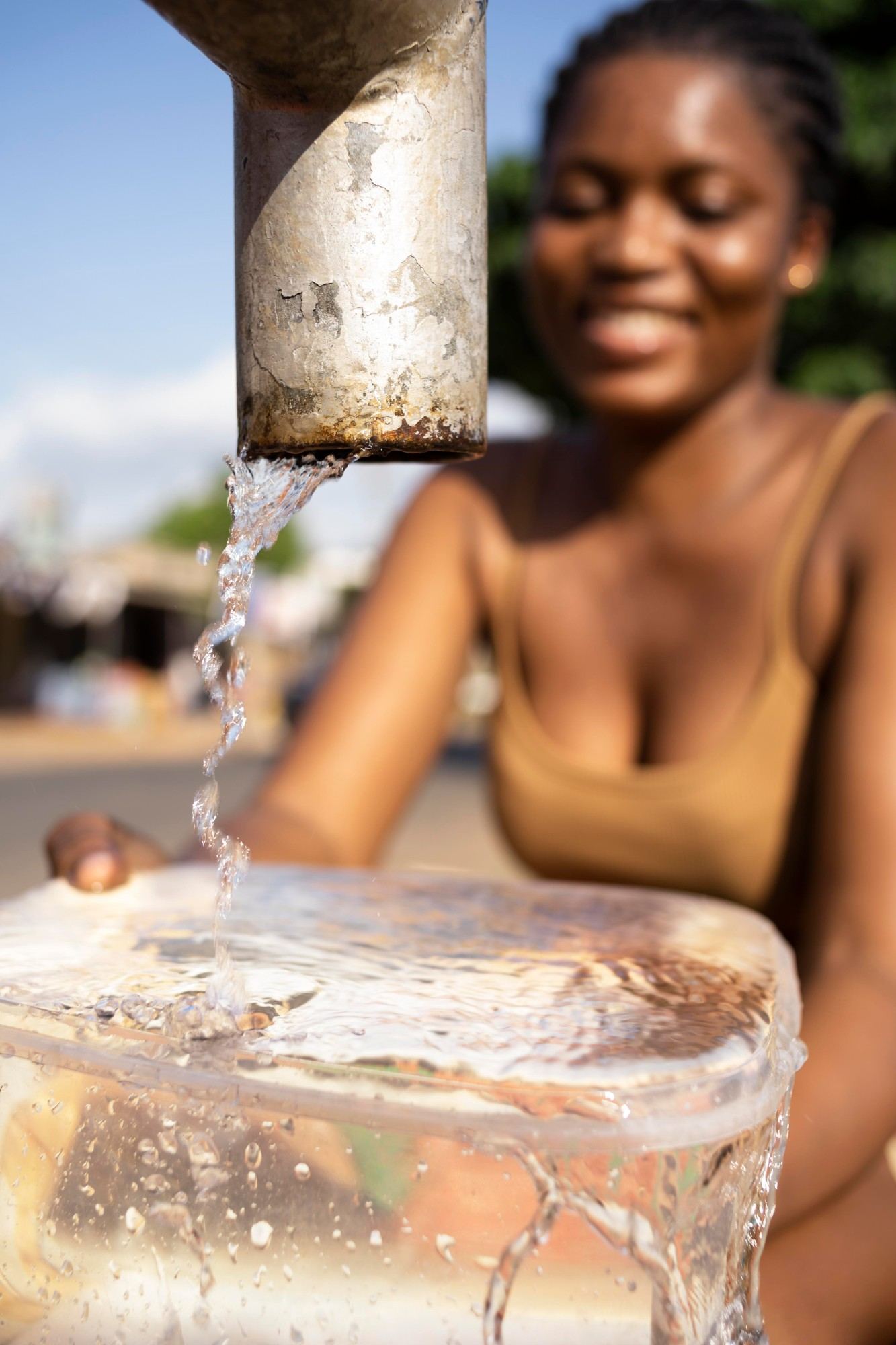 Young woman accessing clean water, WASH programmes